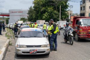 Inspectores del INTRANT y agentes de la DIGESETT fiscalizando unidades del transporte público en una avenida de Santiago.